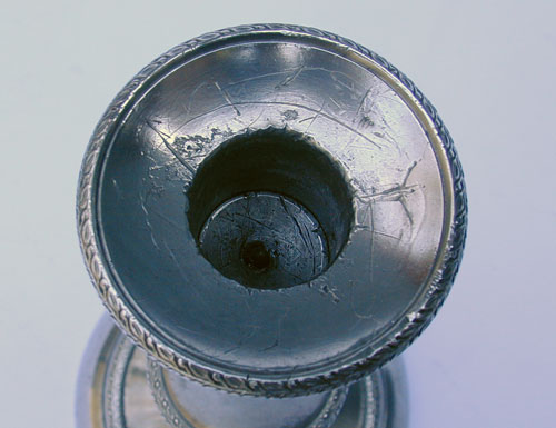 A Pair of Cast Decorated Push-Up Pewter Candlesticks