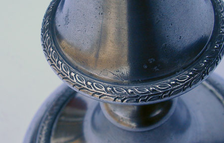 A Pair of Cast Decorated Push-Up Pewter Candlesticks