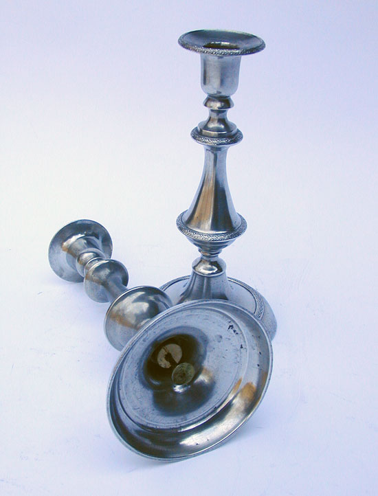 A Pair of Cast Decorated PushUp Pewter Candlesticks